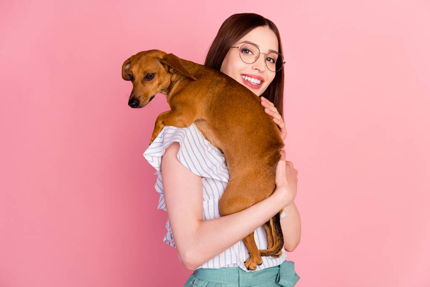 Photo of cute brunette millennial lady hold dog wear eyewear white blouse isolated on pink color background - Foto, imagen