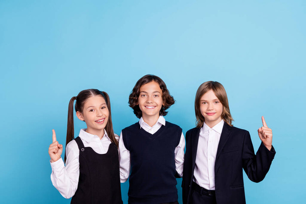 Photo portrait school mates smiling in uniform pointing finger up blank space isolated pastel blue color background - Zdjęcie, obraz