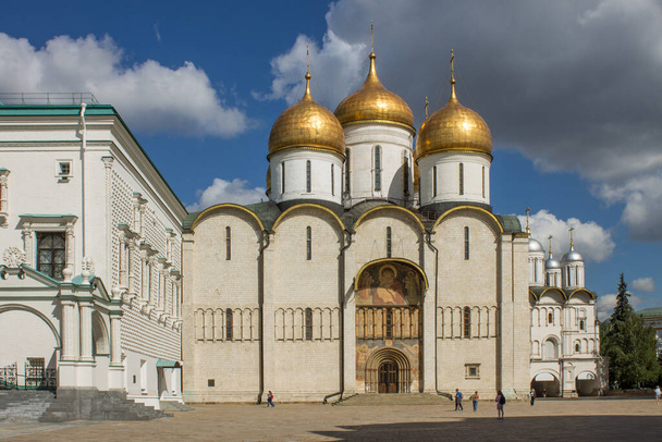 MOSCOW, RUSSIA-AUGUST, 4, 2021: de witte stenen Hemelvaart kathedraal met gouden koepels op het Kathedraal plein van het Kremlin op een zonnige zomerdag - Foto, afbeelding