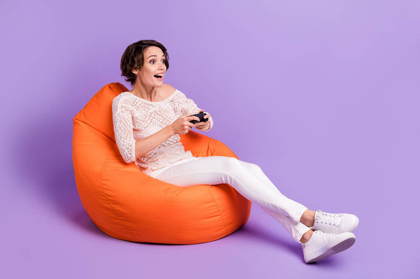 Full Size Profilfoto von aufgeregten Person sitzen weichen Stuhl suchen leeren Raum isoliert auf violettem Hintergrund - Foto, Bild
