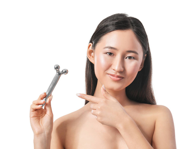 Beautiful young woman with massage tool on white background - Photo, Image