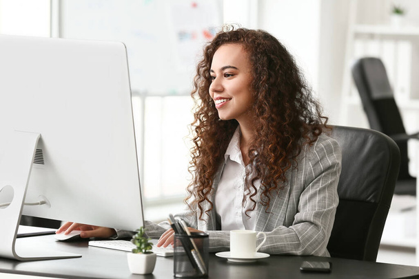 Beautiful young woman working with computer in office - Photo, Image