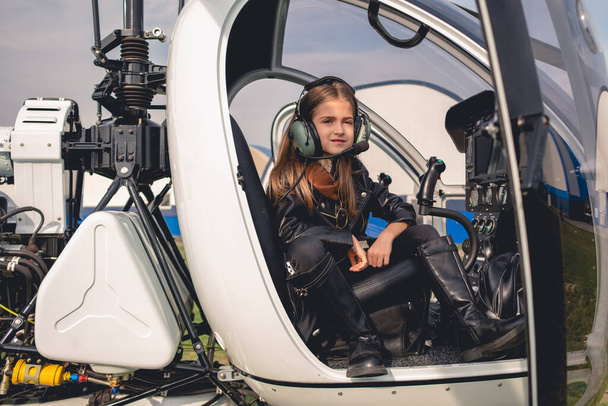 Confiant entre fille dans casque pilote assis dans le cockpit de l'hélicoptère - Photo, image