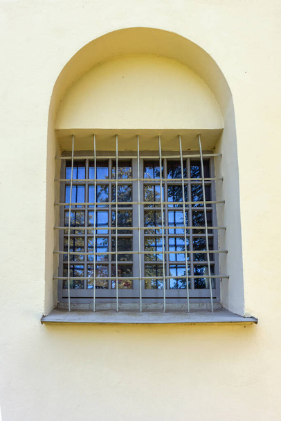 Старое окно с металлической решеткой на стене здания - Фото, изображение