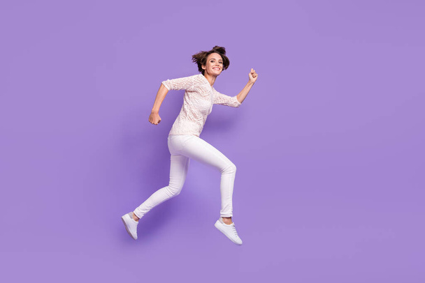 Full body profile portrait of cheerful charming girl running look camera isolated on purple color background - 写真・画像