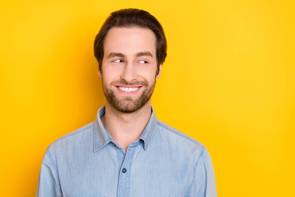Photo portrait of young man smiling looking copyspace wearing jeans shirt isolated on bright yellow color background - Photo, image