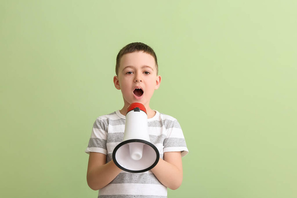 Kleiner Junge mit Megafon-Training spricht Buchstaben auf farbigem Hintergrund aus - Foto, Bild