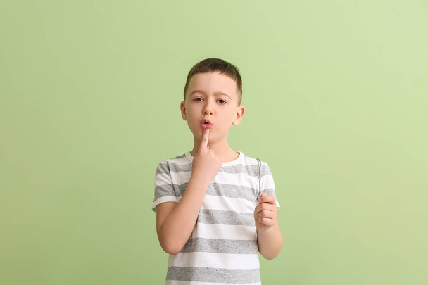 Μικρό αγόρι με logopedic εργαλείο για τη διόρθωση της ομιλίας στο φόντο χρώμα - Φωτογραφία, εικόνα