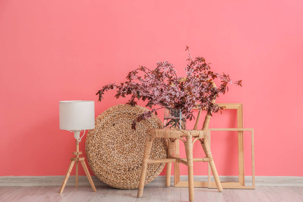 Vaso com ramos florescentes na cadeira perto da parede de cor - Foto, Imagem