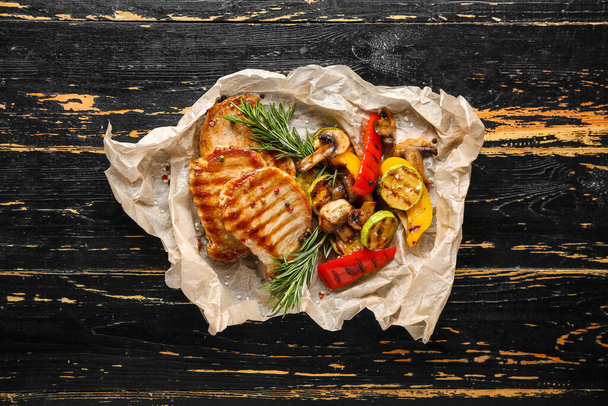 Tasty grilled vegetables and steaks on dark wooden background - Photo, Image