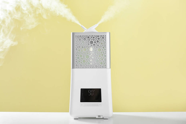 Modern humidifier on table against color background - Photo, Image