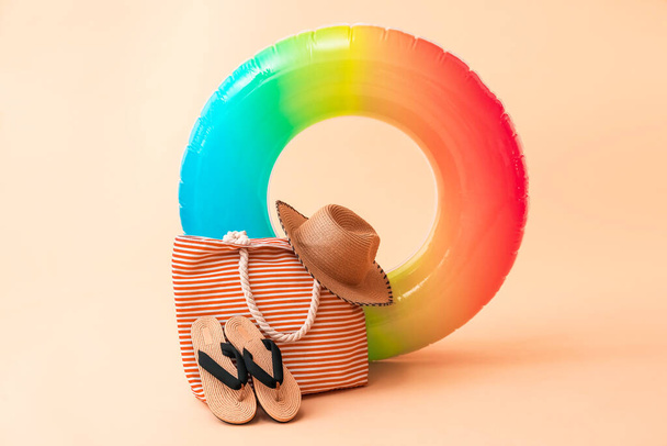 Anillo, bolso, sombrero y chanclas inflables en el fondo del color - Foto, Imagen