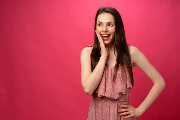 Shocked and surprised girl screaming against pink background - 写真・画像