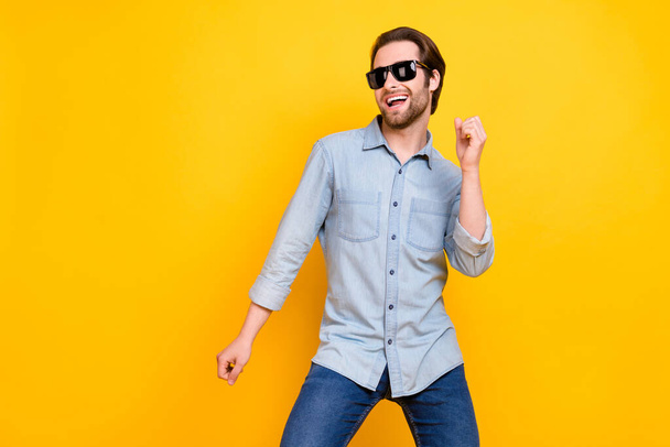 Photo of young cheerful man happy positive smile enjoy music dance wear eyeglasses isolated over yellow color background - Photo, image
