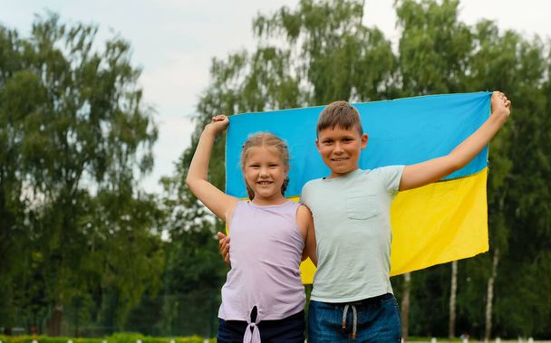 Ukrainische Kinder mit gelb-blauer Fahne der Ukraine im Stadion. Tag der ukrainischen Unabhängigkeitsflagge. Verfassungstag. Flaggensymbole der Ukraine. Kiew, Kiewer Tag - Foto, Bild