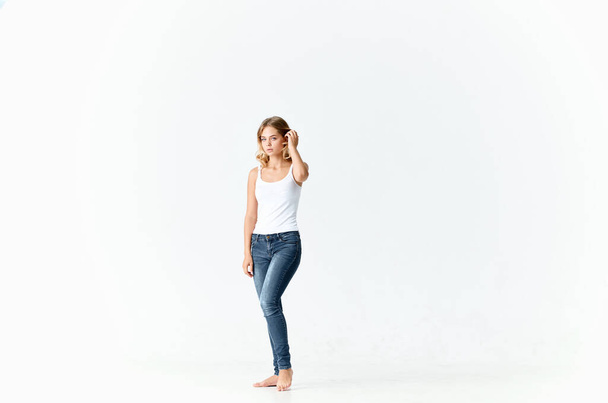 pretty blonde in jeans barefoot posing on  isolated background. High quality photo - Fotó, kép