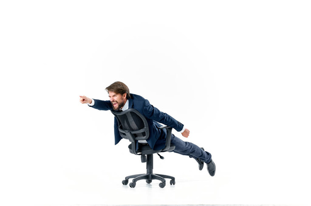 Hombre de negocios alegre en un traje está rodando en la silla. Foto de alta calidad - Foto, Imagen