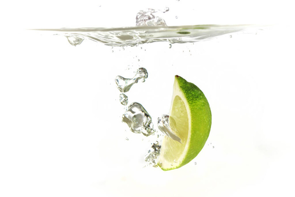 beyaz arkaplanda izole edilmiş limon ve limon sıçrama suyu - Fotoğraf, Görsel