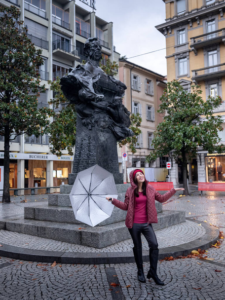 Frau mit Regenschirm posiert an Strasse, Lugano, Schweiz - Foto, Bild