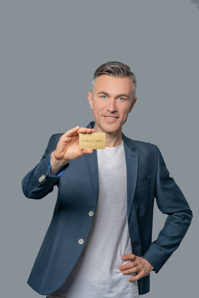 Joyful successful man showing bank card - Foto, afbeelding