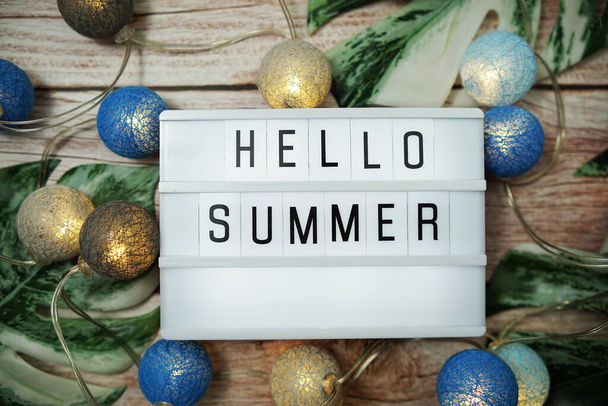 Hello Summer word in lightbox with LED cotton balls decoration on wooden background - Photo, image