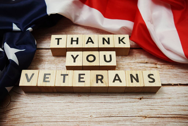 Happy Veterans Day alphabet letter and American flag on wooden background - Fotó, kép