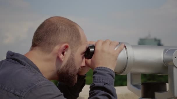 Крупный план кавказца, смотрящего через объектив телескопа - Кадры, видео