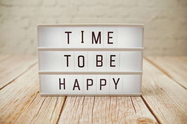 Time To Be Happy word in light box on wooden background - Φωτογραφία, εικόνα