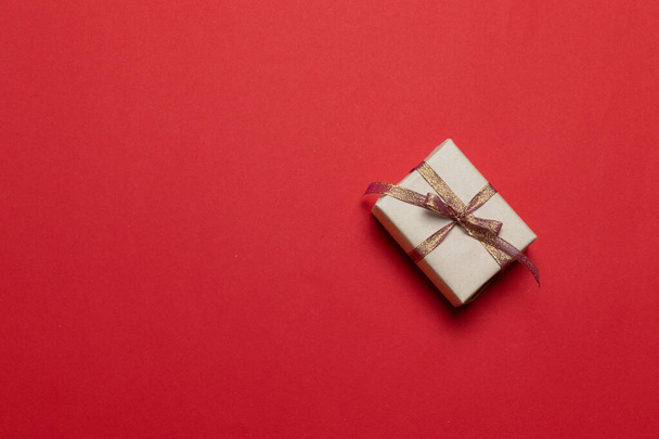 Uusi vuosi Jouluyllätys lahja käsintehty lahjapaketti punaisella taustalla. - Valokuva, kuva