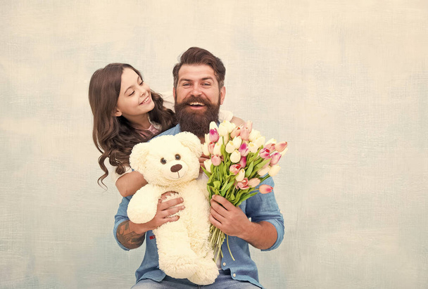 we love each other. teen girl and dad hold tulip bouquet. 8 march or womens day. spring holiday gift. love and family values. happiness. happy family day. father and daughter with flowers and toy - 写真・画像