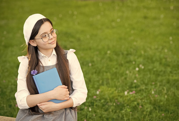Elegant schoolgirl child girl reading book in park, poetry writer concept - Fotografie, Obrázek