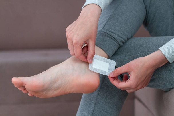 Usar yeso adhesivo médico bactericida en casa durante el uso de zapatos nuevos. Cuidado de la piel de los pies y prevención de callos y callos. Primera banda de ayuda  - Foto, Imagen