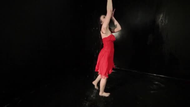 Жінка в червоній сукні співає під час танців, стоячи у воді
. - Кадри, відео
