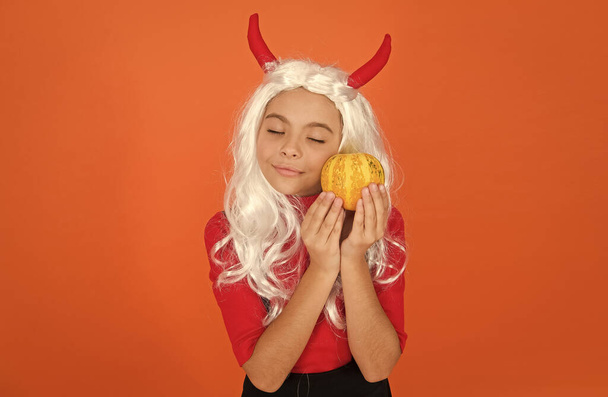 Lost in thoughts. jack o lantern. happy halloween. kid wear devil horns. child with pumpkin. teen girl wear long curly white hair wig for party celebration. autumn season holiday. childhood leisure - 写真・画像