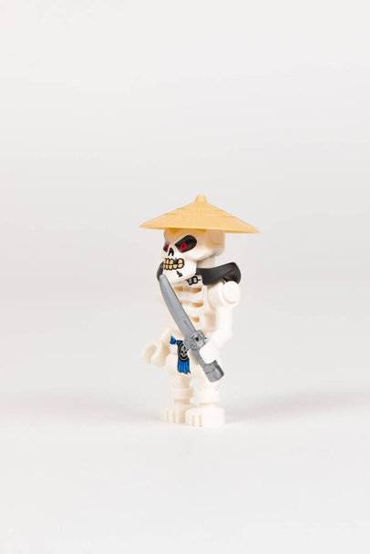 Ecaterimburgo. A Rússia. 04.08.2021. Esqueleto de herói de brinquedo Wyplash em um chapéu de palha com uma espada de um jogo de lego ninjago em um fundo branco. close-up. foco seletivo - Foto, Imagem