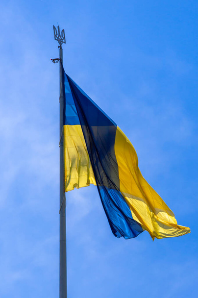 Ukrajna nemzeti zászlója fúj a szél a kék égen. - Fotó, kép