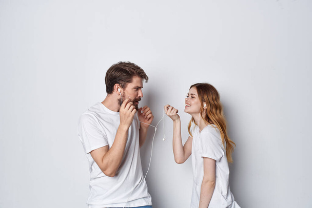 mężczyzna i kobieta w białych koszulkach stoją obok przyjaźni zabawy lekkie tło - Zdjęcie, obraz