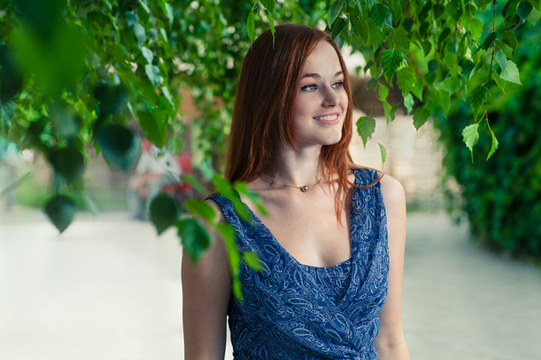 Red haired woman smiling outdoors - Zdjęcie, obraz