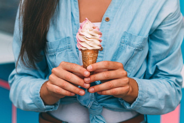 Woman holding fresh sweet ice cream cone in summer hot weather near the ice cream truck  - Foto, afbeelding