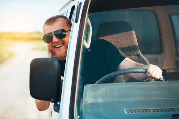 Happy cheerful driver in sunglasses driving a car - 写真・画像