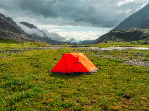 Camping on a summer green high-altitude plateau. Orange tent after the rain. Peace and relaxation in nature. - Fotoğraf, Görsel