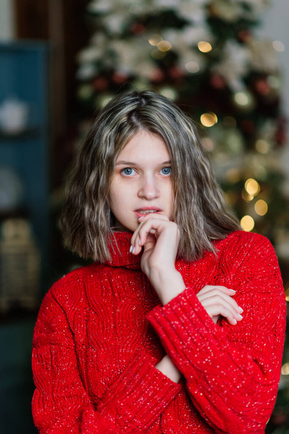 Beautiful young woman celebrating christmas at home, having fun opening presents - Foto, immagini