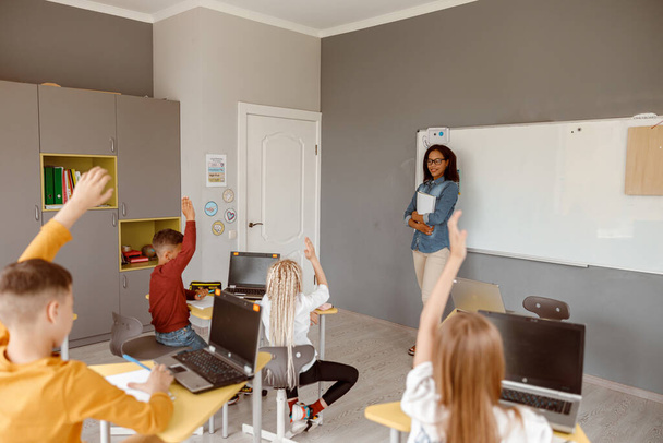 Jungen und Mädchen sitzen während des Unterrichts im Klassenzimmer - Foto, Bild