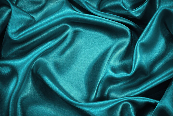  Hermoso fondo de satén de seda verde azul. Pliegues suaves ondulados. Fondo de tela sedosa de lujo con espacio para el producto y el diseño. Banner web.                               - Foto, Imagen