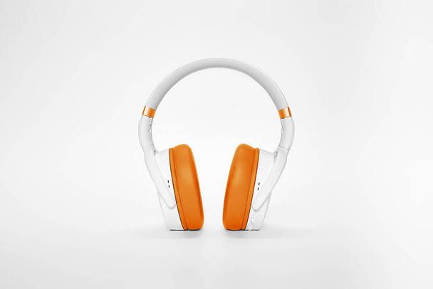 Moderne weiße und orangefarbene Kopfhörer auf weißem Hintergrund - Foto, Bild