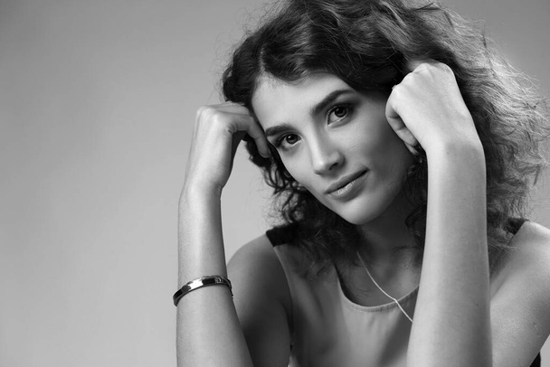 Studio black-and-white portrait of a beautiful girl with a charming smile - Zdjęcie, obraz