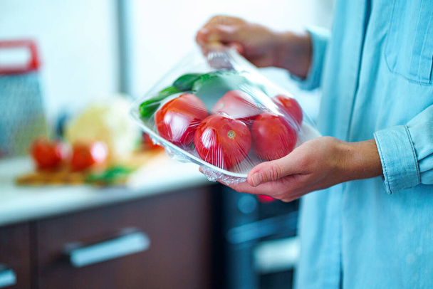 Woman packaged fresh vegetables using food film for food storage in fridge - Photo, Image