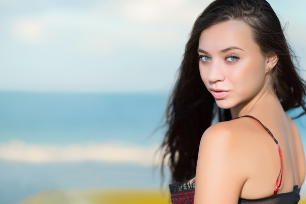 sexy brunette die zich voordeed op het strand - Foto, afbeelding