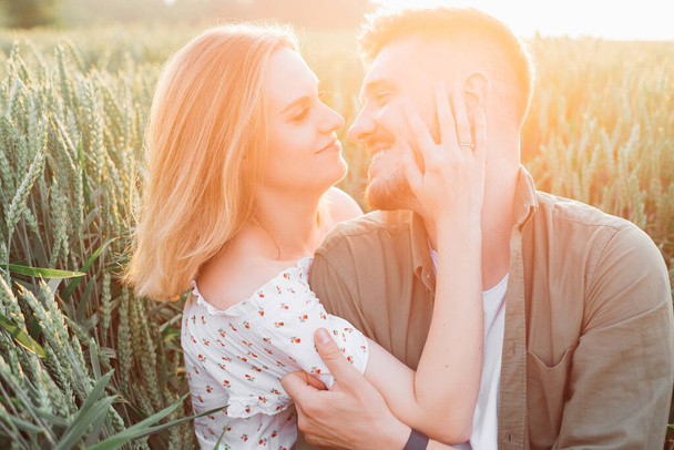 Beautiful young couple is happy to be together on summer evening in rays of setting sun. Love and tenderness. Beautiful moments of life. Youth and beauty. Peace and carelessness. - Photo, Image