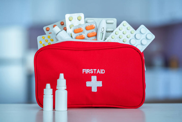Medical first aid kit with medicine and pills on table at home  - Photo, Image